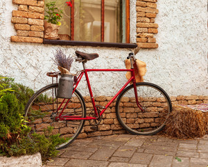 Bicycle with flowers near the window of a dwelling house