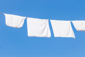 close up of pillow cases hanging for dry with the sun with background of blue sky in summer. 