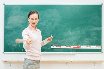 Strenge Lehrerin zeigt mit Zeigestock auf jemanden