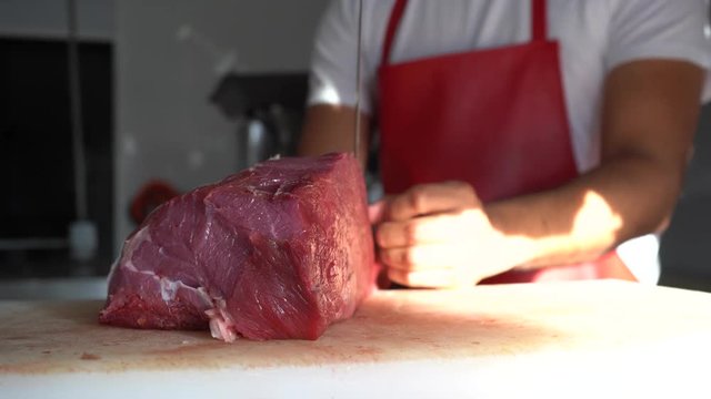 El carnicero se está preparando para empezar a cortar la carne.