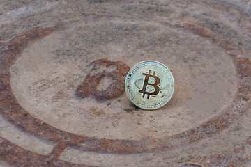 Coin bitcoin on the sewer with the letter B. The concept of the fall of bitcoin and the crisis