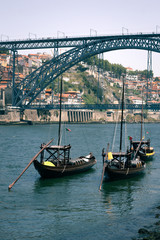 Landscape View Of Luis I Bridge In Porto, Portugal. Landscape view of Luis I bridge in Porto, Portugal. In the river sail the typical Portuguese boats with barrels of wine. Travel Concept.