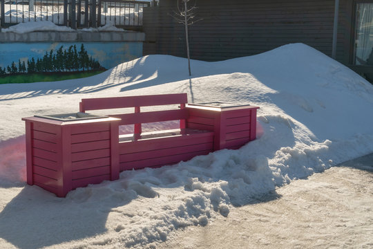 Bright Pink Park Bench In The City In The Snow In Winter.