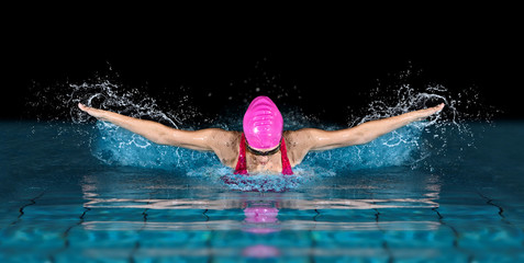 Woman in swimming pool. Butterfly  style