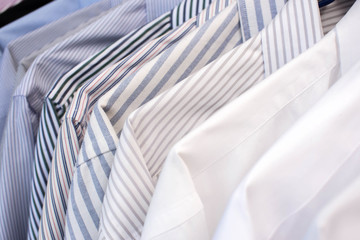 Men shirts hanging on rack in a row, Selective Focus