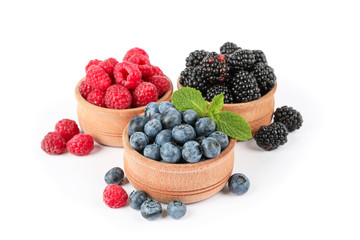 Wooden bowls with berries isolated on white background