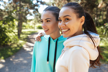 Attractive smiling fitness woman wearing hoodies working out