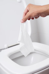 man throwing a wet wipe to the toilet