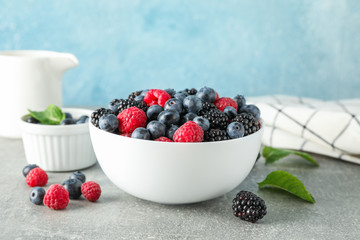 Composition with ceramic dishes and berries on grey table
