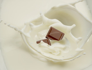 Chocolate salpicando leche.  Chocolate splashing milk.