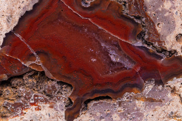 Crystal texture background. Closeup of red brown mineral crystal which enclosed in stone and polished. Macro.