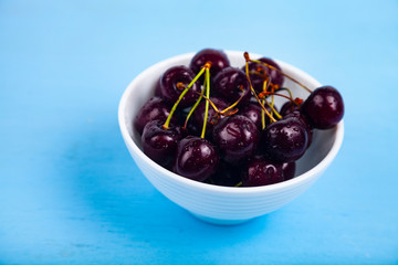 Ripe sweet cherry in a white bowl