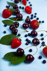 Naklejka na ściany i meble Ripe berries on a blue wooden background.