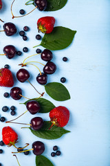 Naklejka na ściany i meble Ripe berries on a blue wooden background.