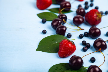 Ripe berries on a blue wooden background.