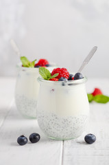 Chia seed pudding with fresh berries on a white wooden table, selective focus.
