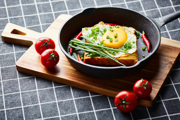 Scrambled eggs on the bread in the frying pan with vegetables - 277402762