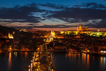 Fototapeta premium Top view of Prague castle, St. Vitus Cathedral, Vltava river and Charles bridge at night. Prague, Czech Republic