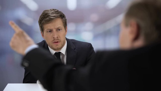 Boss throwing presented business plan to young entrepreneur, dismissal from job