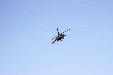 Helicopter flying against the blue sky. Flying a helicopter in the sky. Russian helicopter MI8 against the sky. Helicopter hovers in the sky