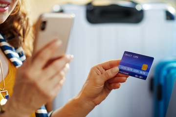 Closeup on trendy woman with credit card booking tickets