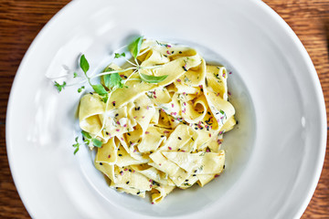 Fresh pasta with creamy sauce on whit plate