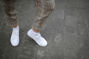 White Sneaker shoes standing on street. Side view. Copyspace