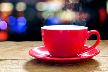 Red coffee mug with smoke on light bokeh background and backdrop. Concept for relaxation
