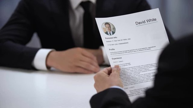 Male candidate presenting CV to HR manager at job interview, first impression