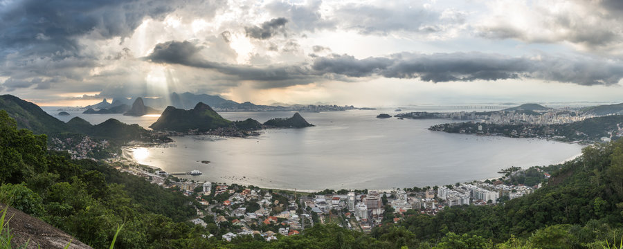 Wide Horizontal Panorama showing S&atilde;o Francisco Beach and Charitas in Niter&oacute;i and Rio de Janeiro City Mountains During a Magical Sunset with Beautiful Light Rays