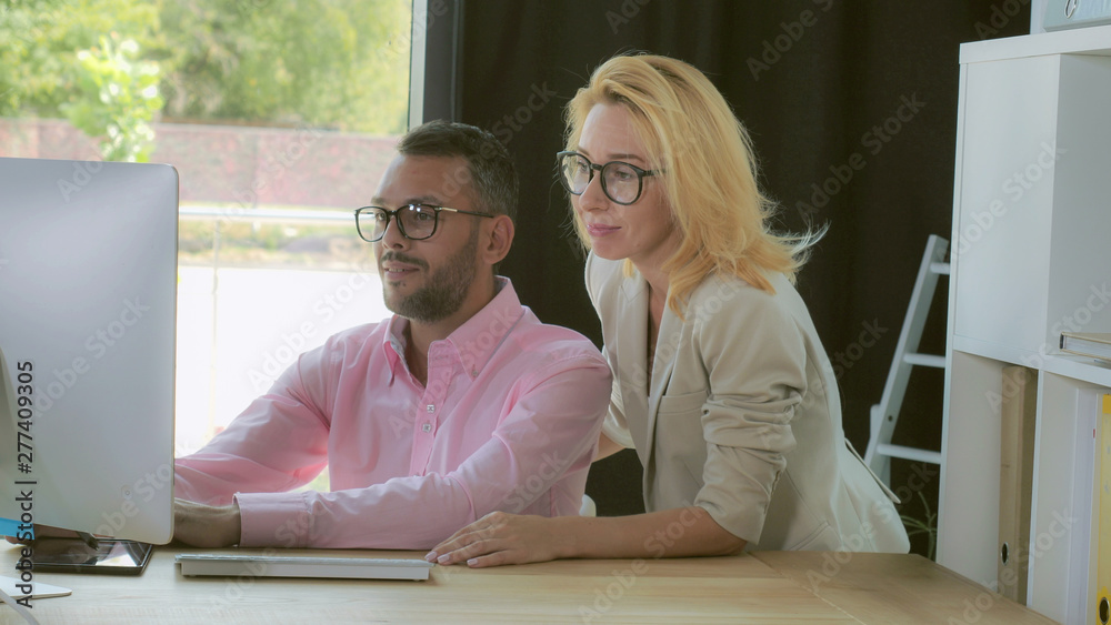 Poster professional business team discussing project looking on screen computer. mixed race man and woman w
