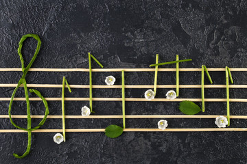 Musical notes conception. Wooden musical notes and flowers
