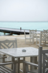 White table restaurant on the beach. The rainy season has begun