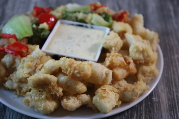 Fried pike zander with vegetablec and with sauce in batter.
