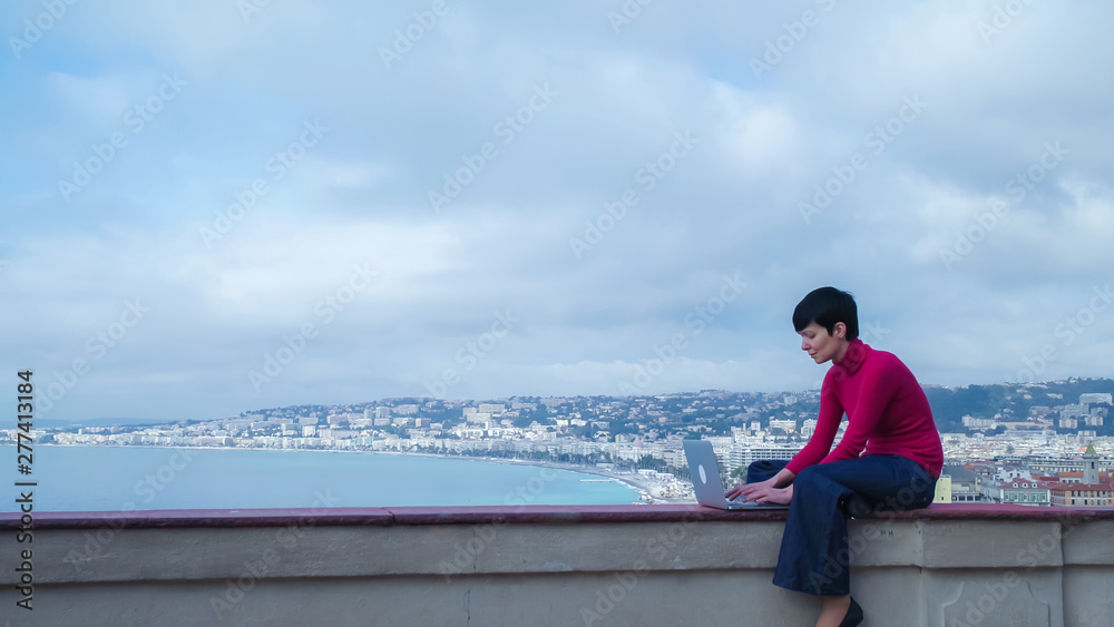 Poster female sitting in front of sea and slouch. caucasian model wearing in jeans and red pullover using l