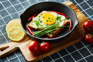 Scrambled eggs on the bread in the frying pan with vegetables - 277413365