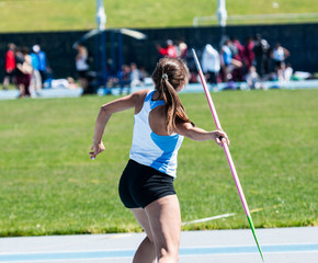 High school teenage girl throwing a pink Javelin in competition