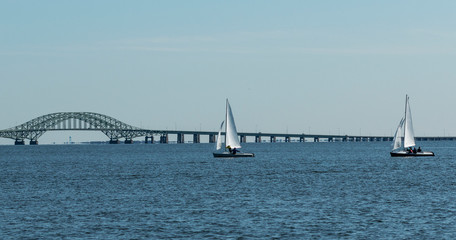 Fototapeta na wymiar Sailboats in the bay with the Robert Mosses bridge in background