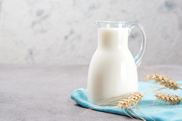 Milk jug on a table, closeup with a copy space