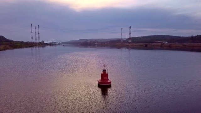 Red marker buoy in calm water