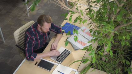 Bearded man flexing his hands and goes to work. Static video