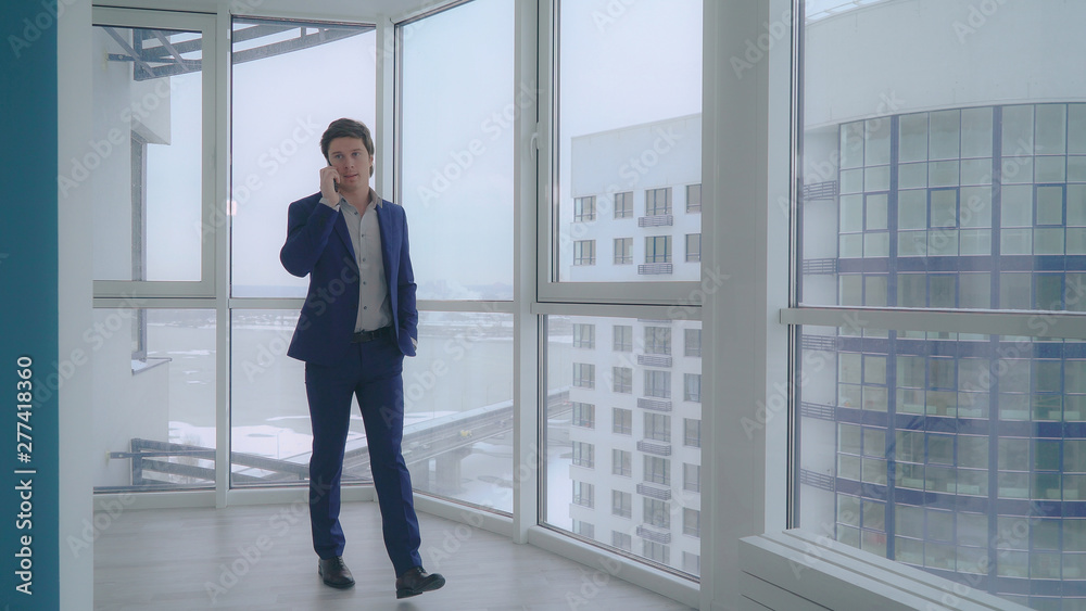 Poster man enters into the flat use smartphone has phone conversation with client. caucasian adult business