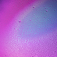 Water droplets on the glass with a colored background. Drops of water.