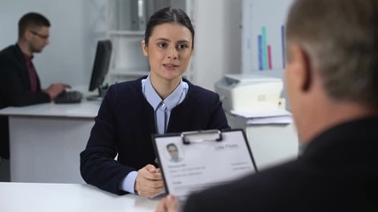 Hiring manager marking resume of unconfident female candidate, hiring at work