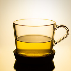 green tea in a glass cup on a cream color background