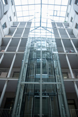 Large glass elevator in a room with a glass ceiling