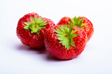 Three red ripe strawberries isolated on white background