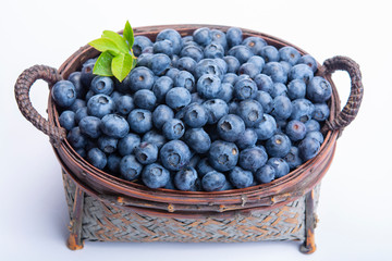 Wicker basket with blueberries, new harvest of healthy berries, isolated on white backgroud