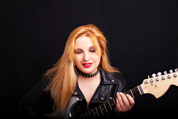 Beautiful blonde girl in rock style on a black background.