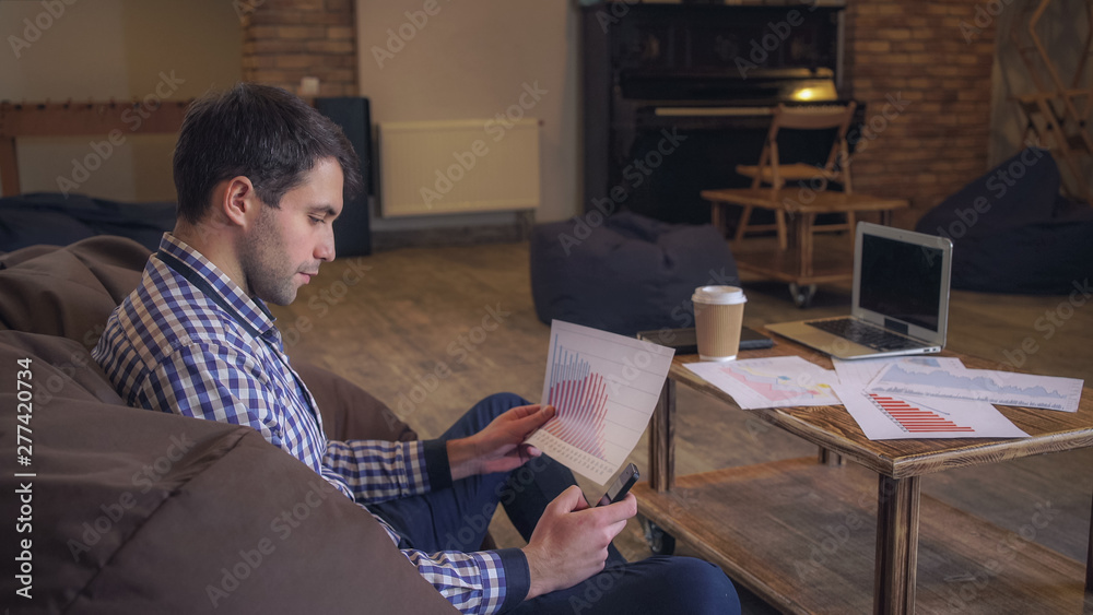 Aufkleber manager working in coworking, in the hands holding the phone checks the data raspechatonym document 
